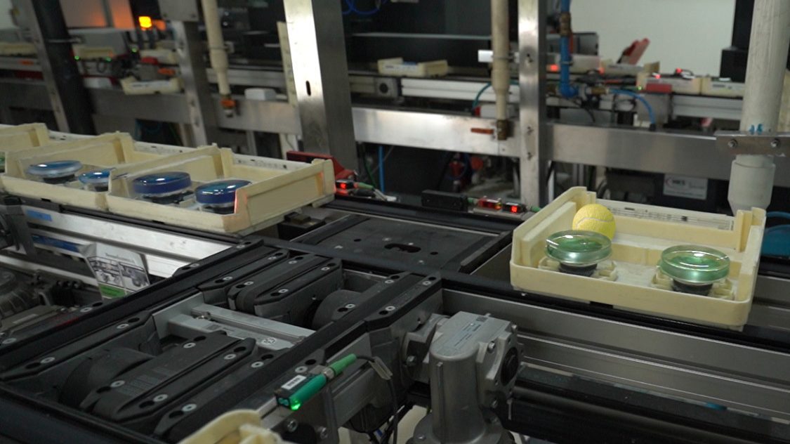Production lien on optical lab shows trays with lenses in 
