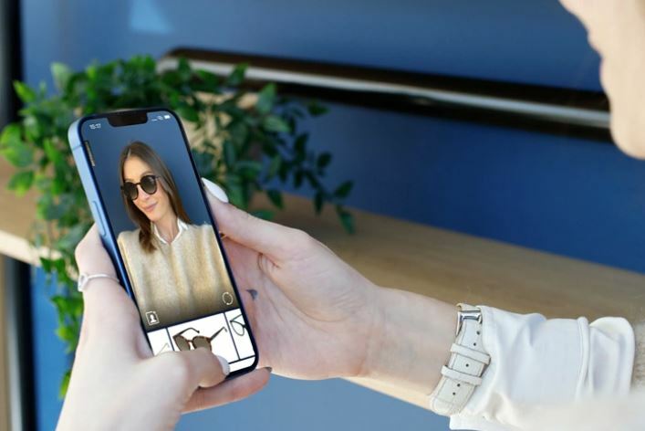 Woman with dark and medium length hair tries sunglasses on using virtual try-on 