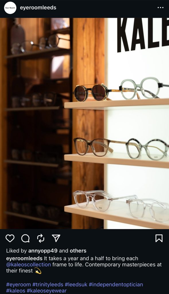 Instagram post from Eyeroom Leeds showcasing a display of Kaleos eyewear. Several stylish frames, including round, square, and transparent designs, are neatly arranged on illuminated shelves. The caption highlights that each Kaleos frame takes a year and a half to craft, describing them as contemporary masterpieces. Hashtags include #eyerroom, #trinityleeds, #independentoptician, #kaleos, and #kaleoseyewear.