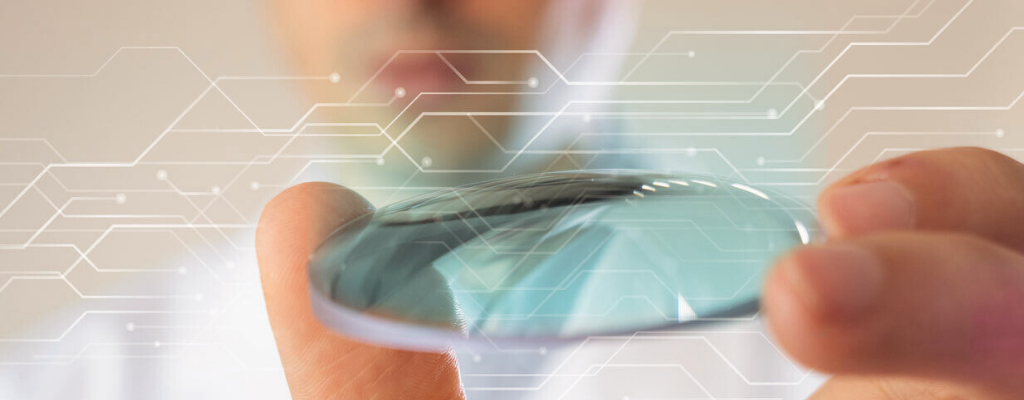 A lab technician holding a finished optical lens, symbolizing automation and innovation powered by Innovations Optical Lab Software.